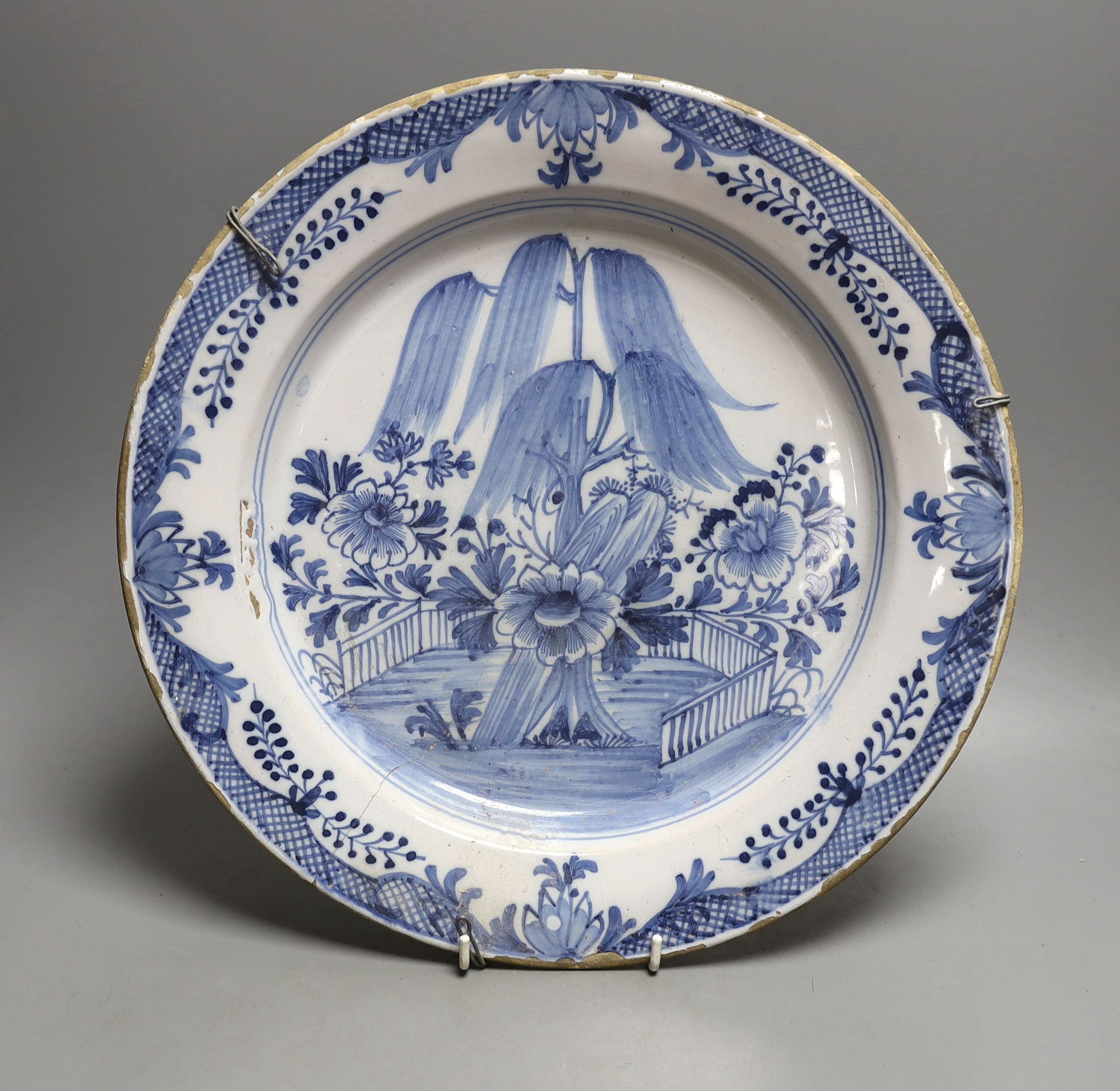 An 18th century Delft blue and white dish with central flower - 36cm diameter